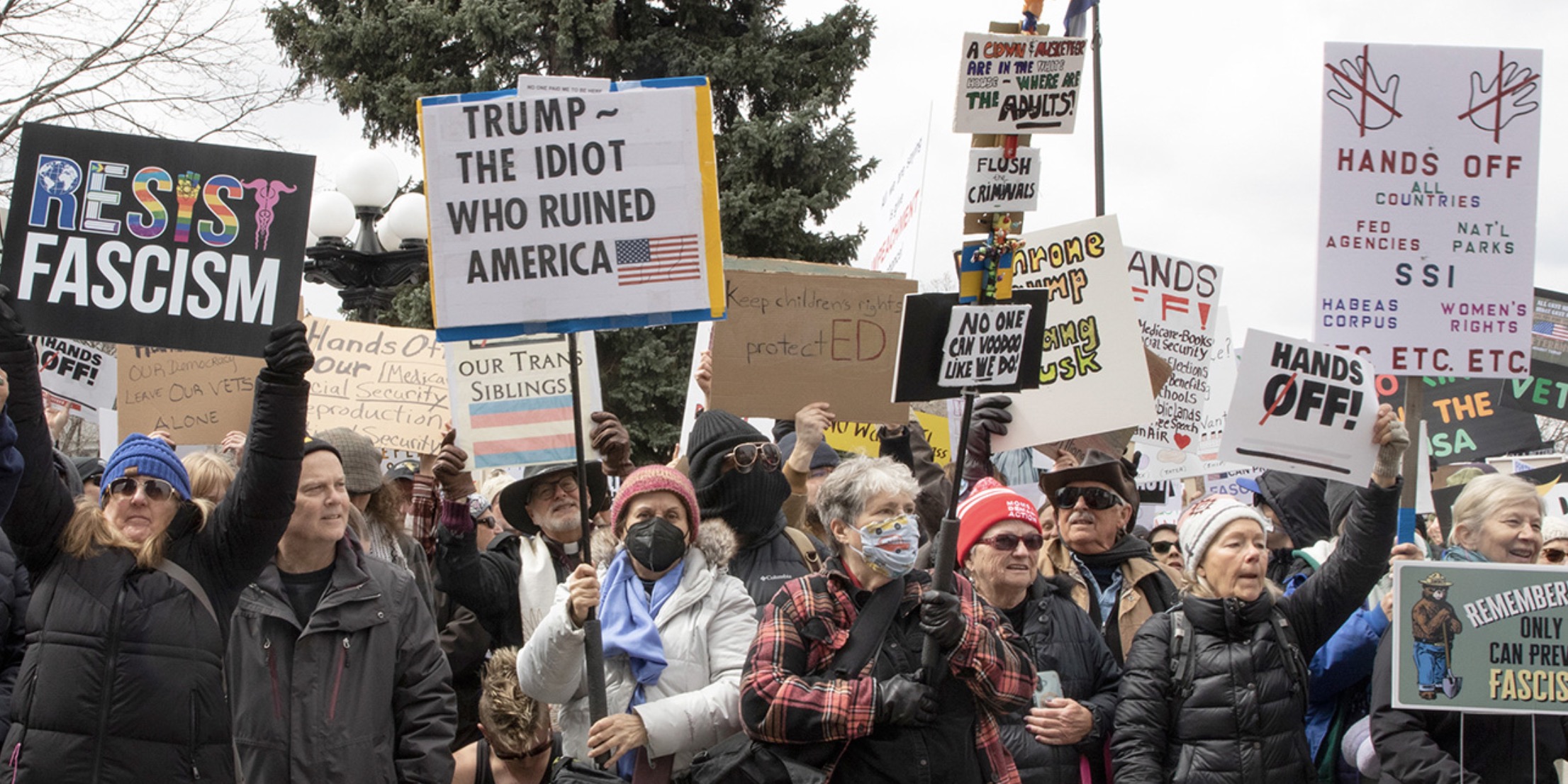 Protesters wave signs at anti-Trump rally, Denver, 4/5/25. Photo: Beth Schneider