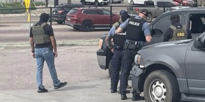 ICE agents surrounding a truck driver at a gas station in Colorado Springs. Photo: CORNN